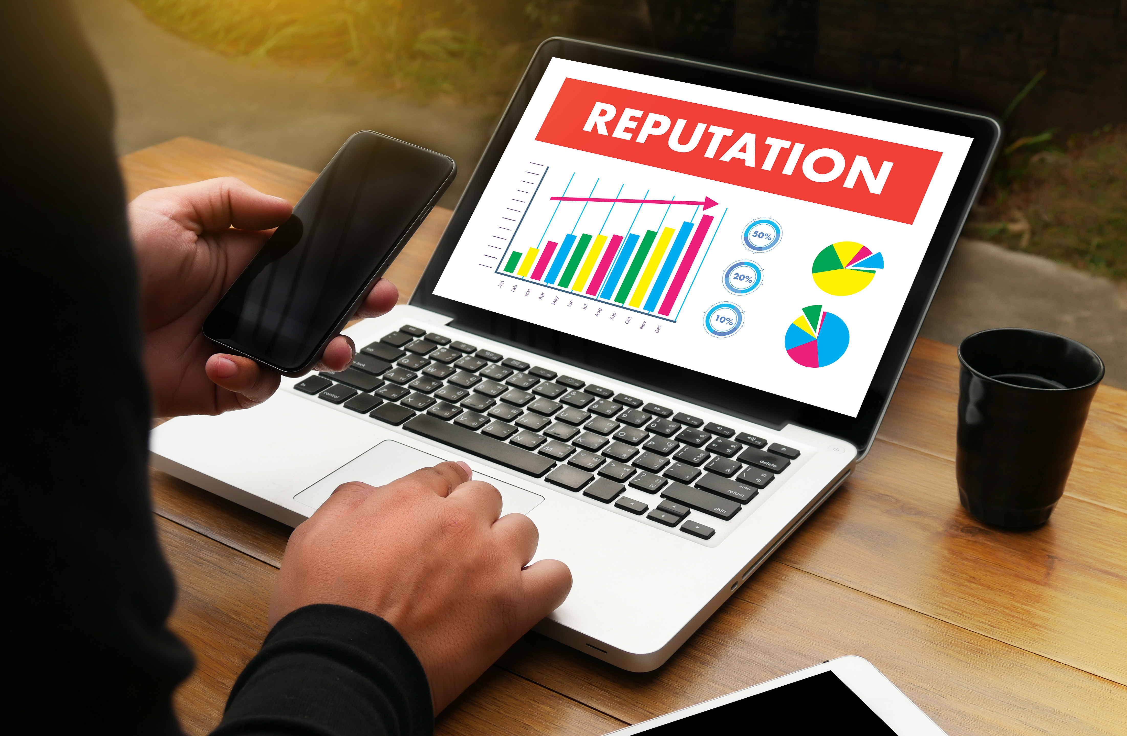 An open laptop with the word 'Reputation' displayed above some graphs